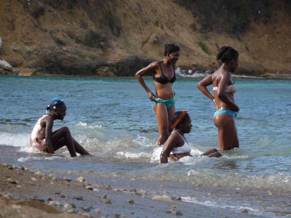 Garotas tomam banho na água do mar, em praia de Cap-Haitien, no norte do Haiti